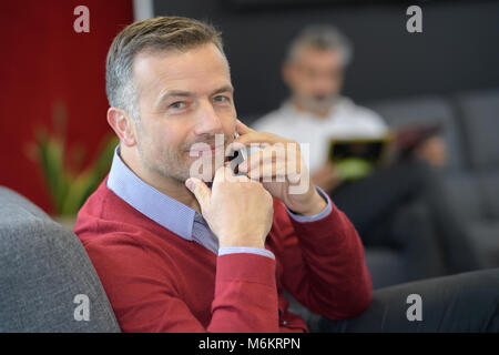 man making call in first class lounge Stock Photo