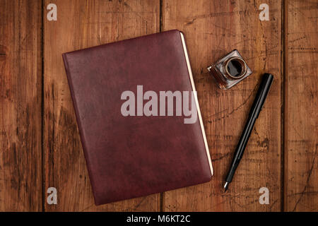 A leather bound journal, and ink well and pen Stock Photo