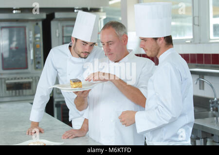 chef and assistants during work in the kitchen Stock Photo