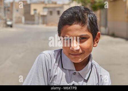 Kashan, Iran - April 27, 2017: Close-up portrait of an unknown Iranian boy, about 12 years old, against a background of a city street on a sunny day. Stock Photo