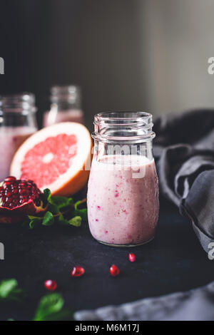 Pink berry smoothie with pomegranate, acai and grapefruit in jar. Toned, selective focus. Healthy lifestyle, fitness, detox, dieting, clean eating, ve Stock Photo