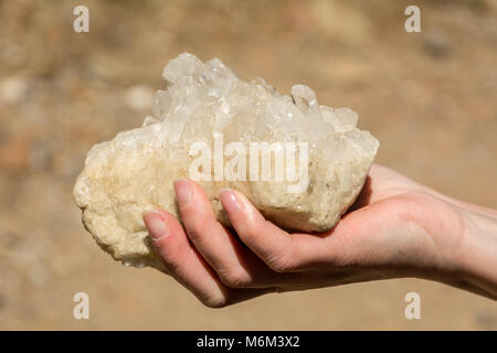 rose quartz in the natural state in one hand.quartz in the natural state before extraction processing Stock Photo