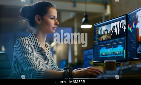 Female Video Editor Works with Footage and Sound on Her Personal Computer. She Works Late. Her Office is Modern and Creative Loft Studio. Stock Photo