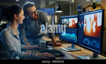 Female Video and Sound Editor Works With Her Male Colleague on Project on Her Personal Computer with Two Displays. They Work in Creative Loft Office Stock Photo