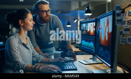 Female Video and Sound Editor Works With Her Male Colleague on Project on Her Personal Computer with Two Displays. They Work in Creative Loft Office Stock Photo