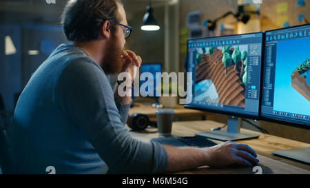 Creative Male Game Developer Works with Graphics for the New Level Design, He Sits at His Wooden Table Working on Two Display Personal Computer. Stock Photo