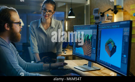 Male Game Developer Talks with Artistic Female Level Designer. Two Displays Show Totally Original Game. They Work in a Creative Office Loft. Stock Photo