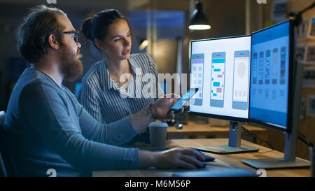 Handsome Male and Beautiful Female Mobile Application Designers Test and Discuss New App Features. They Work on a Personal Computer with Two Displays Stock Photo