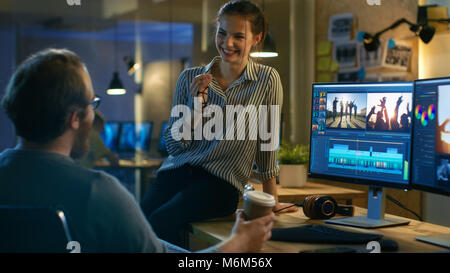 Beautiful Female and Handsome Male Video Editors Discuss Footage They're Working On. They Enjoy Working Together in a Creative Studio. Stock Photo