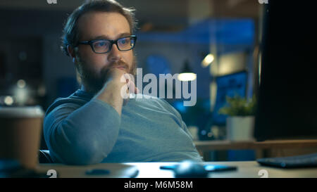 Focused Young Man Sits at His Desk and Thinks on a Problem Solution. Stock Photo