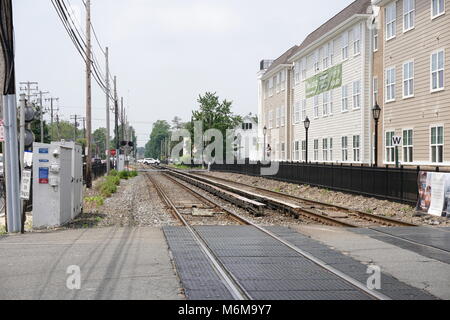 Farmingdale, NY - June 4, 2016: Looking westbound down the LIRR Ronkonkoma branch tracks past new construction and revitalization project in the Long  Stock Photo