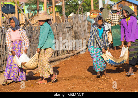 Villagers undertake manual road construction work at West Phwar Saw Village, Bagan, Myanmar (Burma), Asia in February - women moving materials Stock Photo