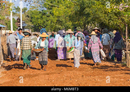 Villagers undertake manual road construction work at West Phwar Saw Village, Bagan, Myanmar (Burma), Asia in February - women moving materials Stock Photo