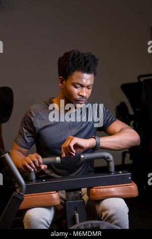 African man looking at smart watch in gymnasium Stock Photo