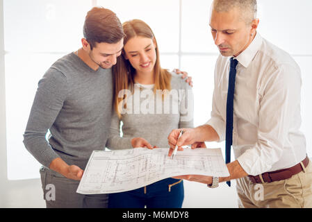 Young couple consult with real estate agent about buying new house. Stock Photo