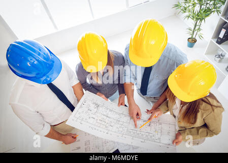 Young architect team discussing construction plans and planning what to change to be better. They are in the office. Top view. Stock Photo
