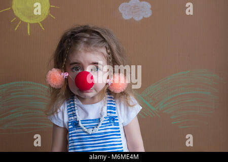 Cute emotional little girl joyful crying. Close up of a sad , upset , crying clown with a red nose Stock Photo