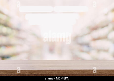 Empty wooden table top with blurred modern shopping mall background for product display and montage. Stock Photo