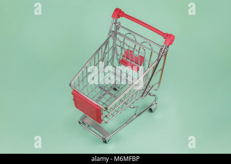 High angle view of shopping trolley toy on green background Stock Photo