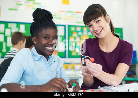 Portrait Of Female Pupil And Teacher Using Molecular Model Kit In Science Lesson Stock Photo