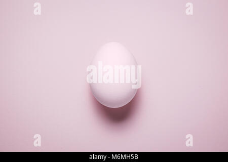 High angle view of isolated plain pink pastel colored egg. Minimal concept. Stock Photo