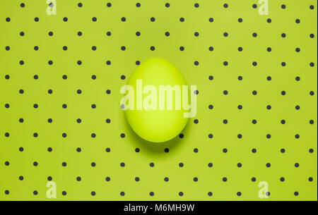 Neon egg on vivid green polka background minimalistic concept Stock Photo