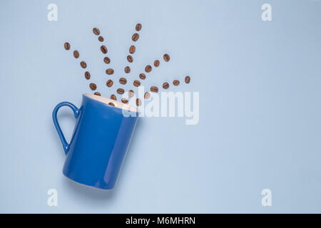 Cup of coffee with beans in shape of vapor on pastel blue background. Flat lay minimal concept. Stock Photo