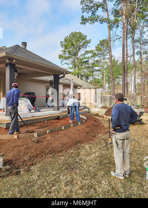 Construction workers at a residential site working on a patio for the home or house in Pike Road Alabama, USA. Stock Photo