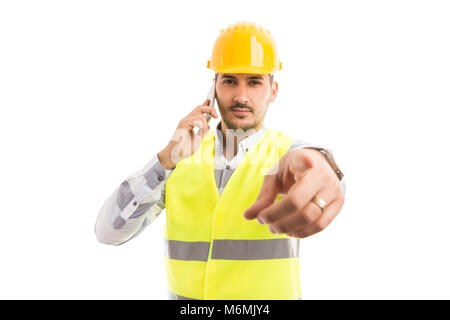 Builder or constructor pointing finger at camera while talking on the phone Stock Photo