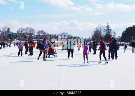 People skating on a bright sunny day during Winterlude on a frozen Rideau Canal Skateway, Ottawa, Ontario, Canada. Stock Photo