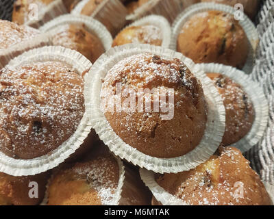 delicious chocolate muffins with powdered sugar in a basket Stock Photo