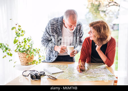 Senior couple with map at home, making plans. Stock Photo
