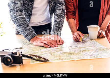 Senior couple with map at home, making plans. Stock Photo