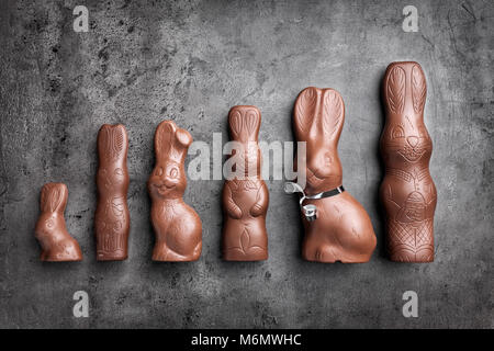 Variety of delicious chocolate Easter bunnies on rustic background Stock Photo