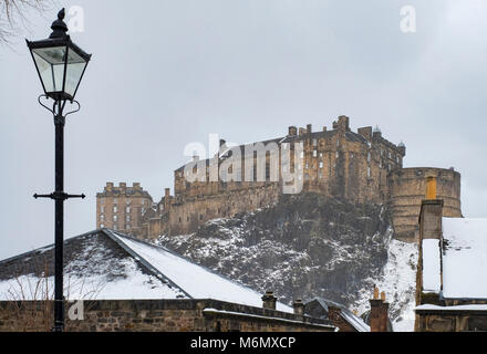 View of Edinburgh Castle across snow covered roofs of houses , Scotland, United Kingdom Stock Photo