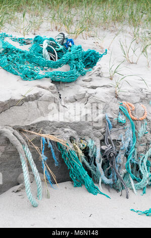 Fishing ropes and nets discarded and entangled in the beach and sand dunes on Howmore beach, South Uist, Outer Hebrides, Scotland, UK Stock Photo