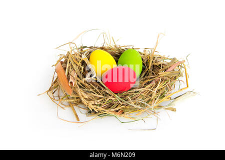 Colorful Easter eggs in Bird's nest From grass dry and straw or natural material isolated on white background. Stock Photo