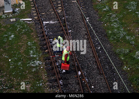 Istanbul, Turkey - March 1, 2018 : Two railroad workers or engineers are walking on the rails at Istanbul, Kadikoy. Theye are carrying equipments. Stock Photo