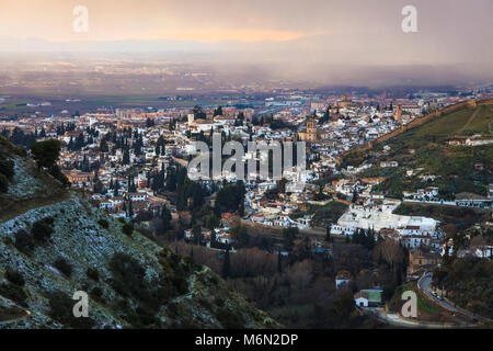 General view of the Unesco listed Albaicin old town and Sacromonte districts of Granada city at sunset as seen from the nearby Cerro del Sol on a snow Stock Photo