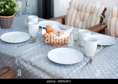 Table setting for breakfast. Pastries, empty cups and plates on a table Stock Photo