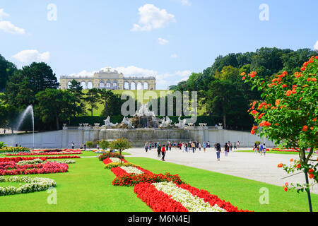 VIENNA,AUSTRIA - SEPTEMBER 4 2017; Landscape of formal gardens leading to Neptune Fountain and Gliorriete baroque structure on distant hill in grounds