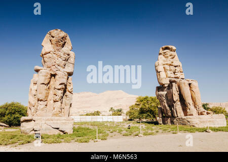 Luxor, Egypt. Colossi of Memnon,  two massive stone statues of the Pharaoh Amenhotep III, who reigned in Egypt during the Dynasty XVIII. Stock Photo