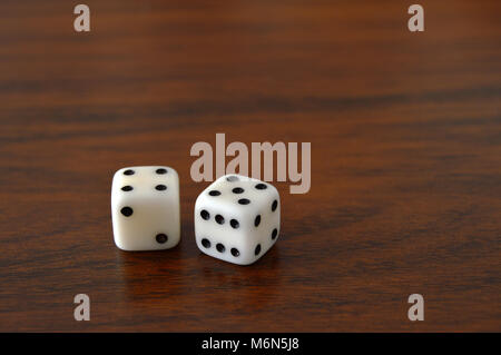 two dice on a dark wooden table Stock Photo