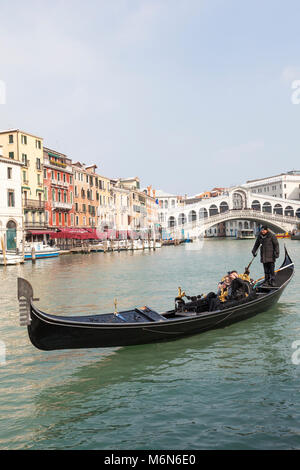 Couple in a gondola on the Grand Canal in winter with light rooftop snow, Rialto Bridge, San Polo,  Venice,  Veneto, Italy in a close up view on a sun Stock Photo