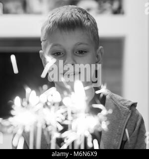 10-year-old Caucasian boy blowing out candles on cake Stock Photo