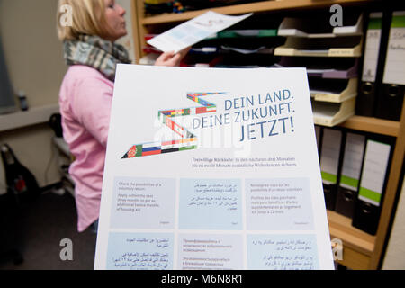 21 February 2018, Germany, Stralsund: Antje Huebner shows information pamphlets for asylum seekers. Since the beginning of the year, she is the first full-time return advisor for asylum seekers in the region. Photo: Stefan Sauer/dpa Stock Photo
