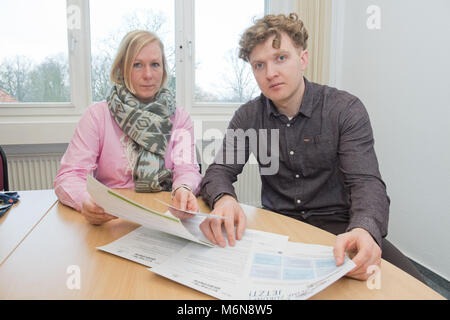 21 February 2018, Germany, Stralsund: Antje Huebner shows information pamphlets to Artur Tatevosyan, who fled from the Ukraine three years ago and was denied asylum in Germany. Since the beginning of the year, Huebner is the first full-time return advisor for asylum seekers in the region. Photo: Stefan Sauer/dpa Stock Photo