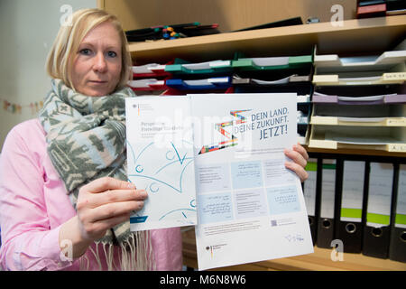 21 February 2018, Germany, Stralsund: Antje Huebner shows information pamphlets for asylum seekers. Since the beginning of the year, she is the first full-time return advisor for asylum seekers in the region. Photo: Stefan Sauer/dpa Stock Photo