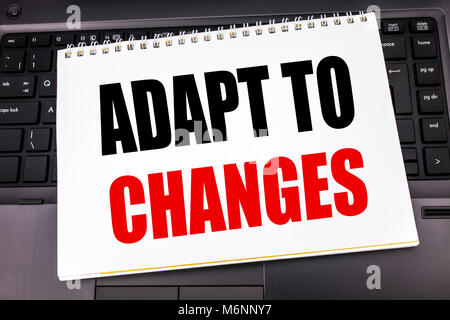 Handwritten text showing Adapt To Changes. Business concept writing for Adaptation New Future written on notepad note paper the black keyboard backgro Stock Photo