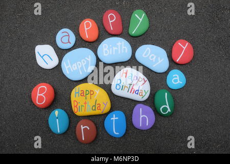 Many Happy Birthday multicolored stones over original black volcanic sand Stock Photo